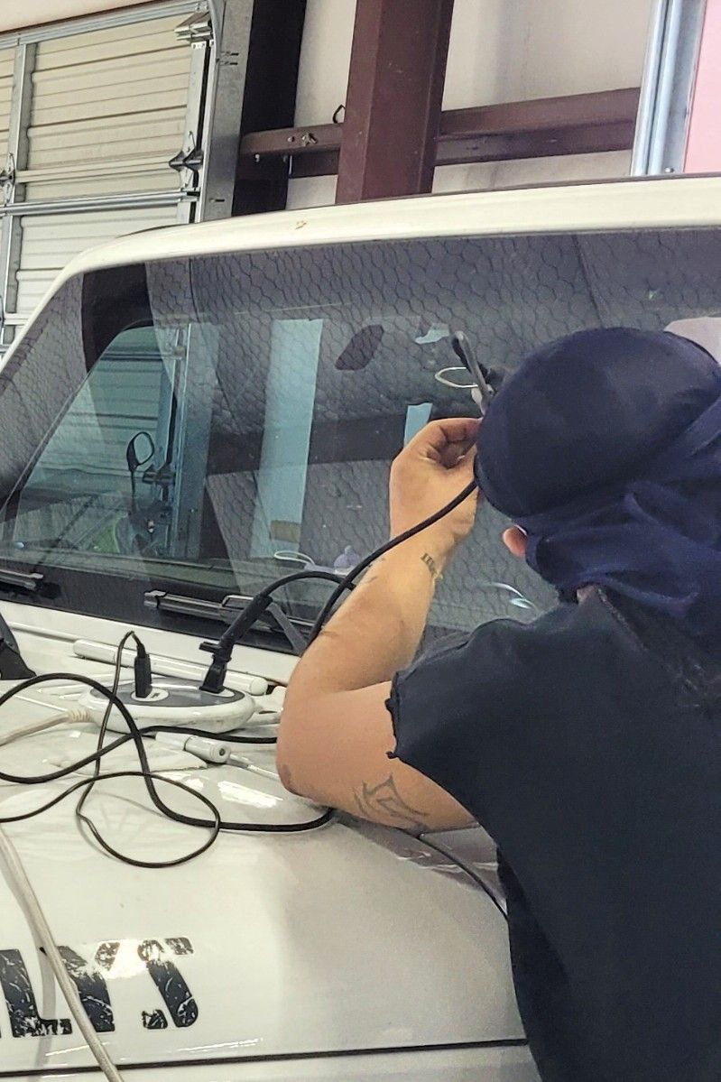 Technician repairing windshield chip with Glasweld Repair system