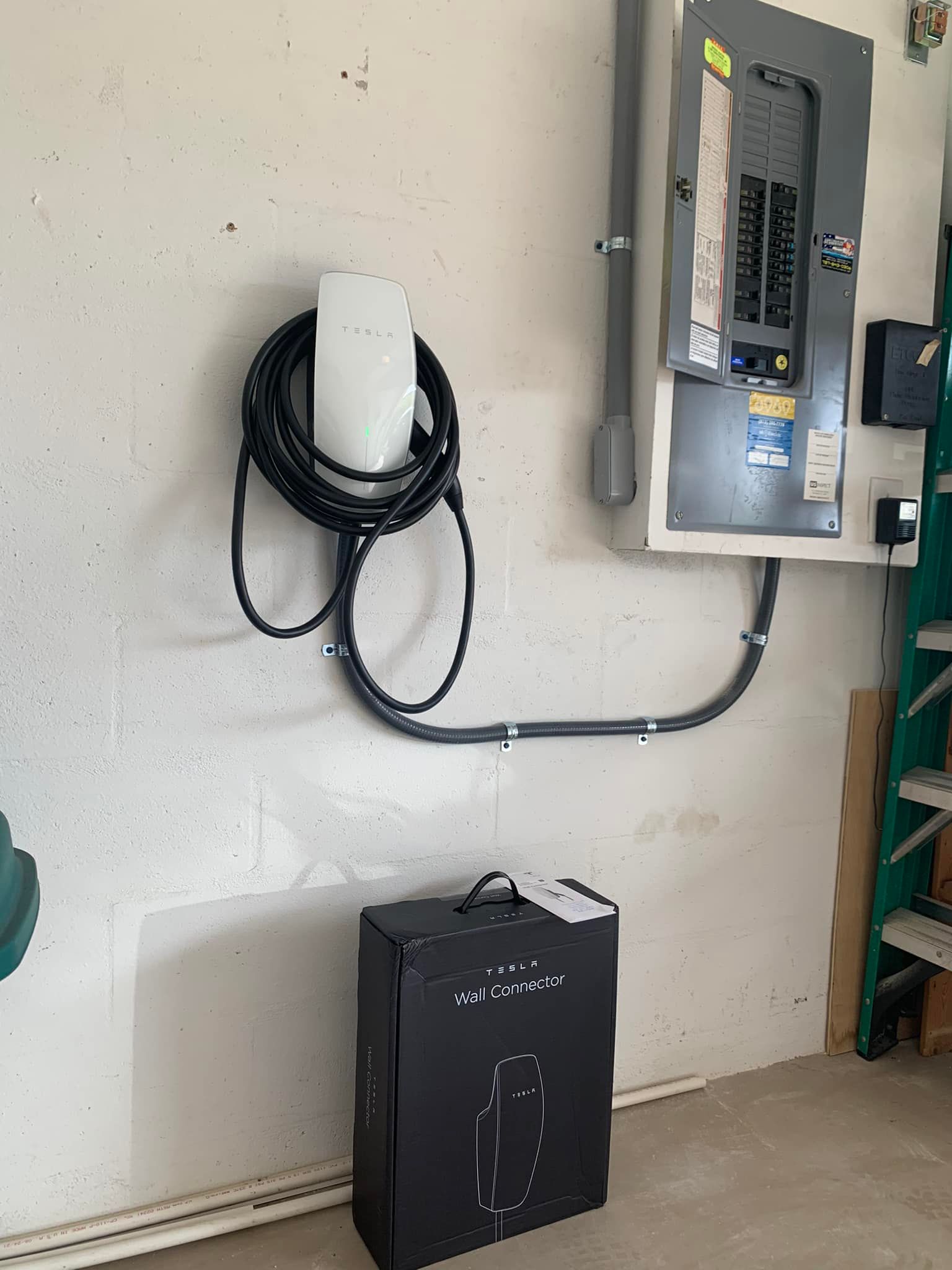 Electrician testing wiring in a control panel with a multimeter inside an electrical cabinet