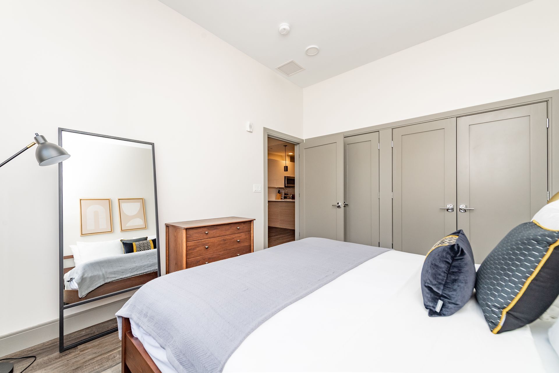 Bedroom with a large mirror, bed, dresser, and closet.