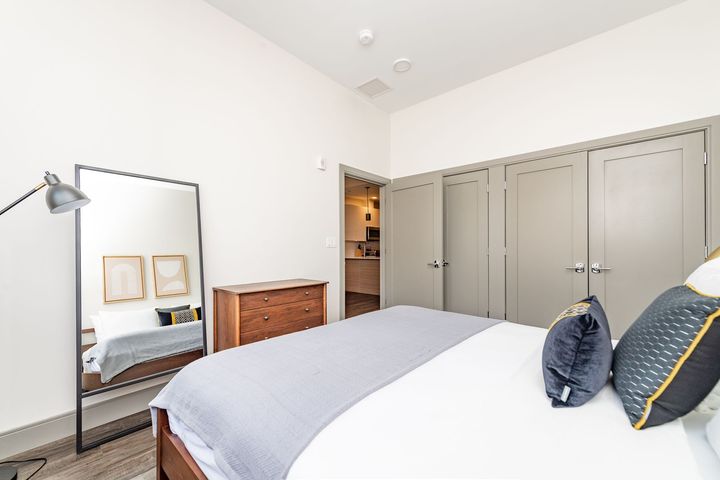 Bedroom with a large mirror, bed, dresser, and closet.