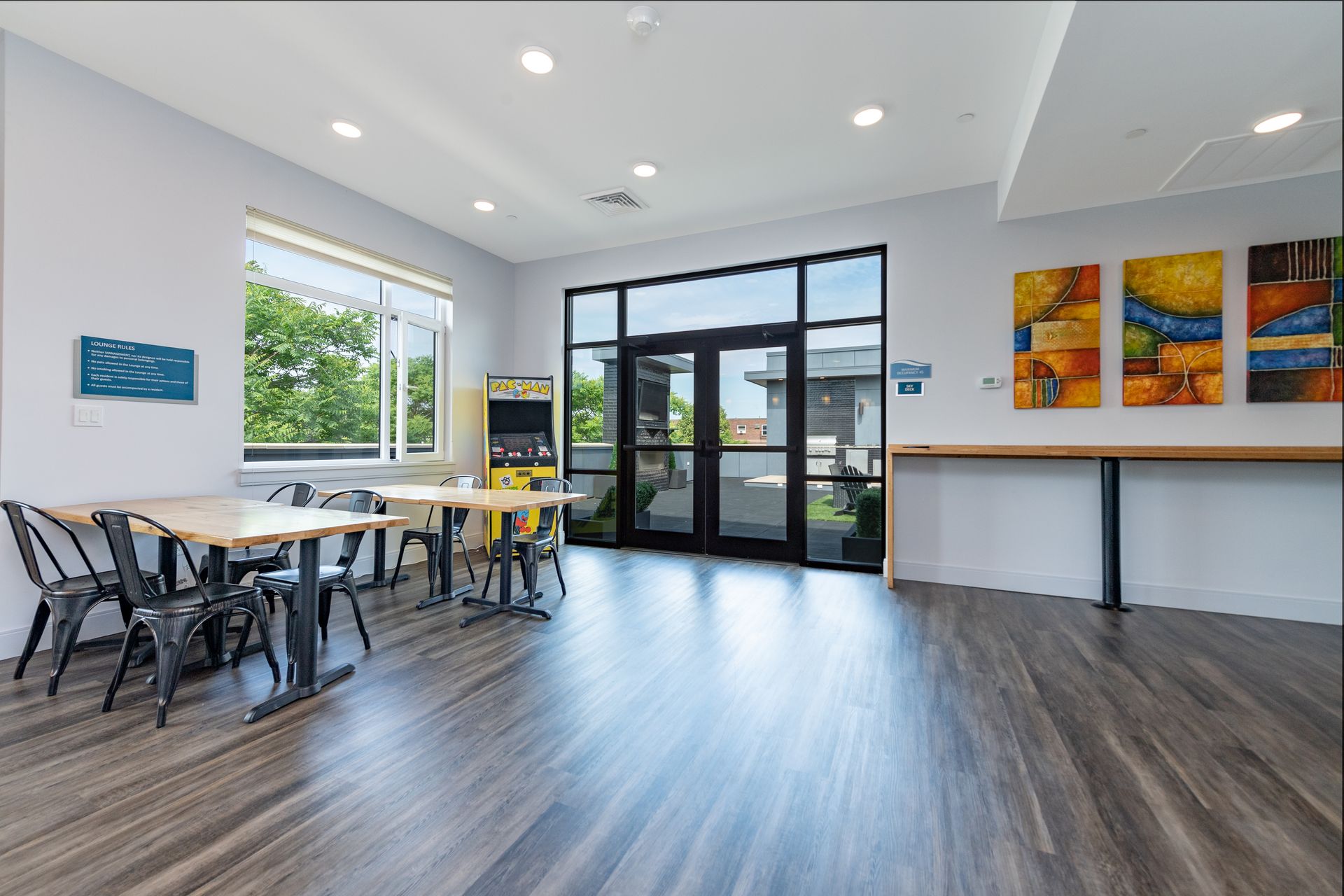 Bright, modern interior with tables, chairs, large windows, and colorful artwork.