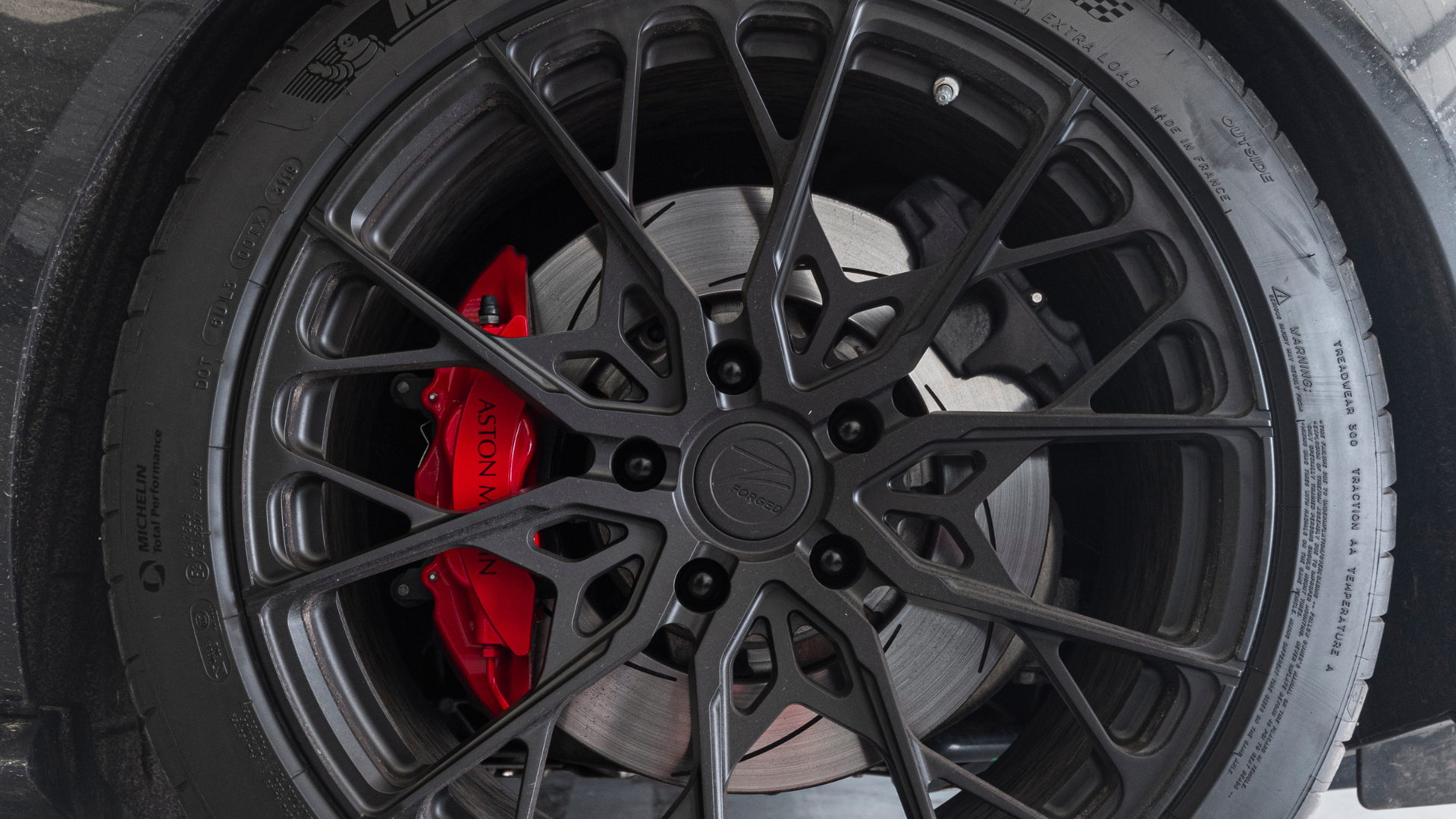 A car with a flat tire is parked on the side of the road.