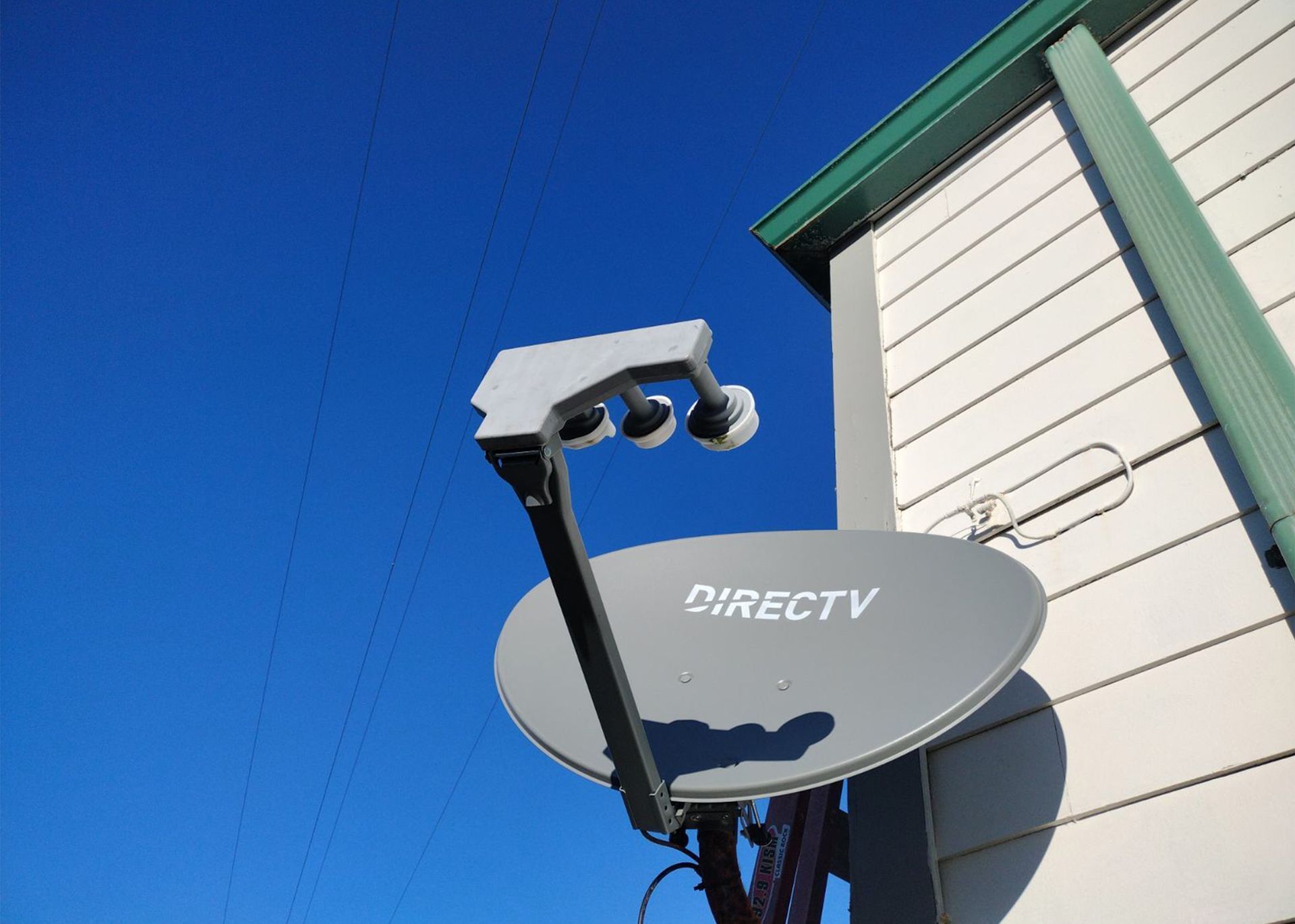A directv satellite dish is mounted on the side of a building