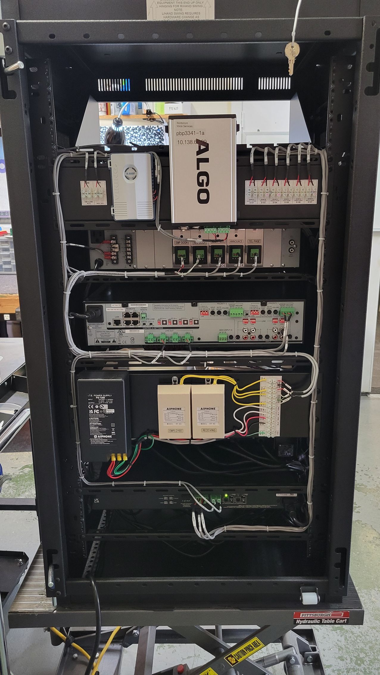 The inside of a server rack with a lot of wires coming out of it.