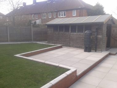 paved patio area and turfed lawn with large garden shed