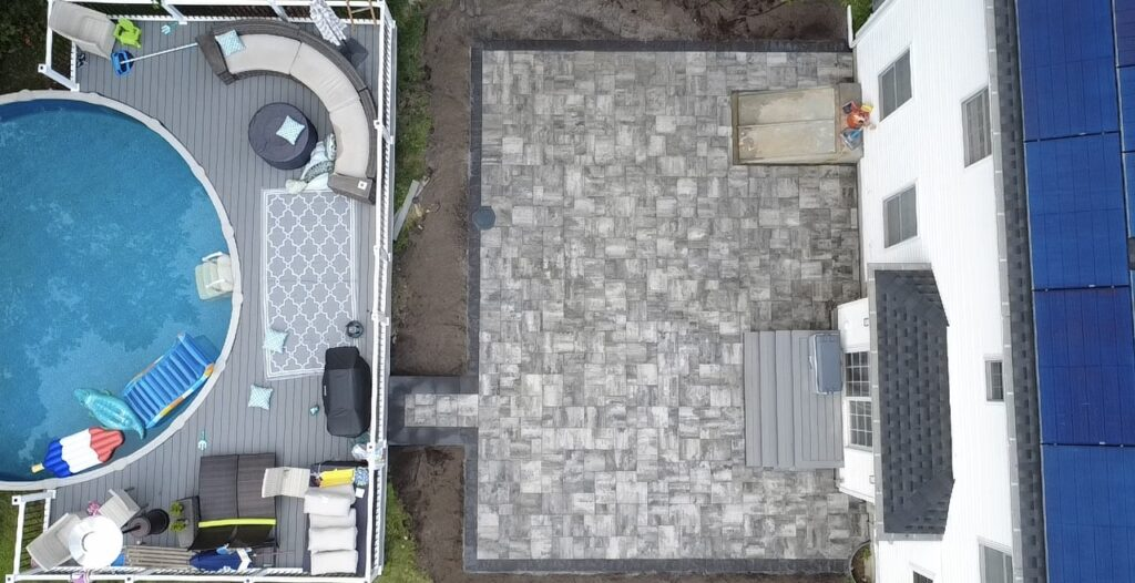 Overhead view of a house with a pool, deck, and patio.