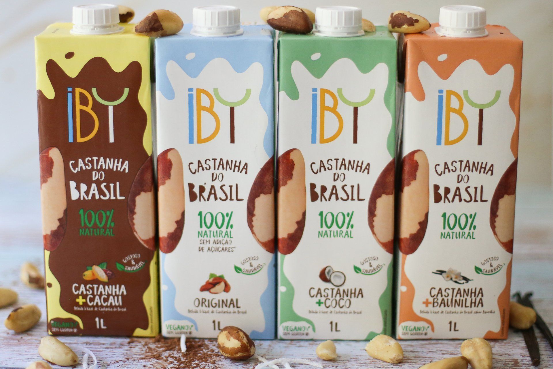 Quatro garrafas de castanha do brasil estão dispostas lado a lado sobre uma mesa.