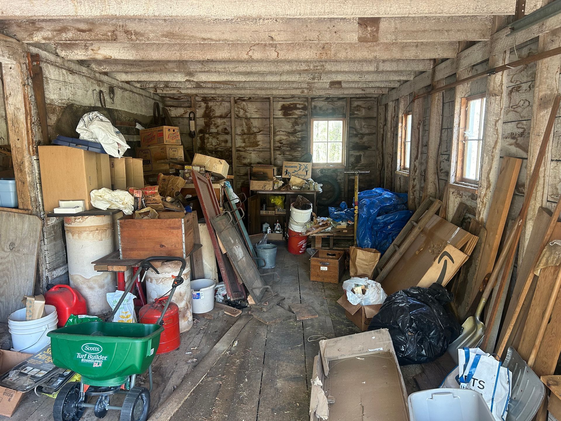 A garage filled with lots of boxes and a green wagon
