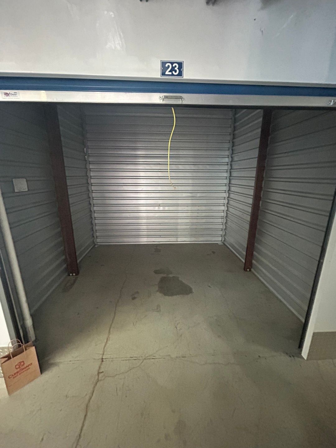 A small empty storage unit with a blue door.