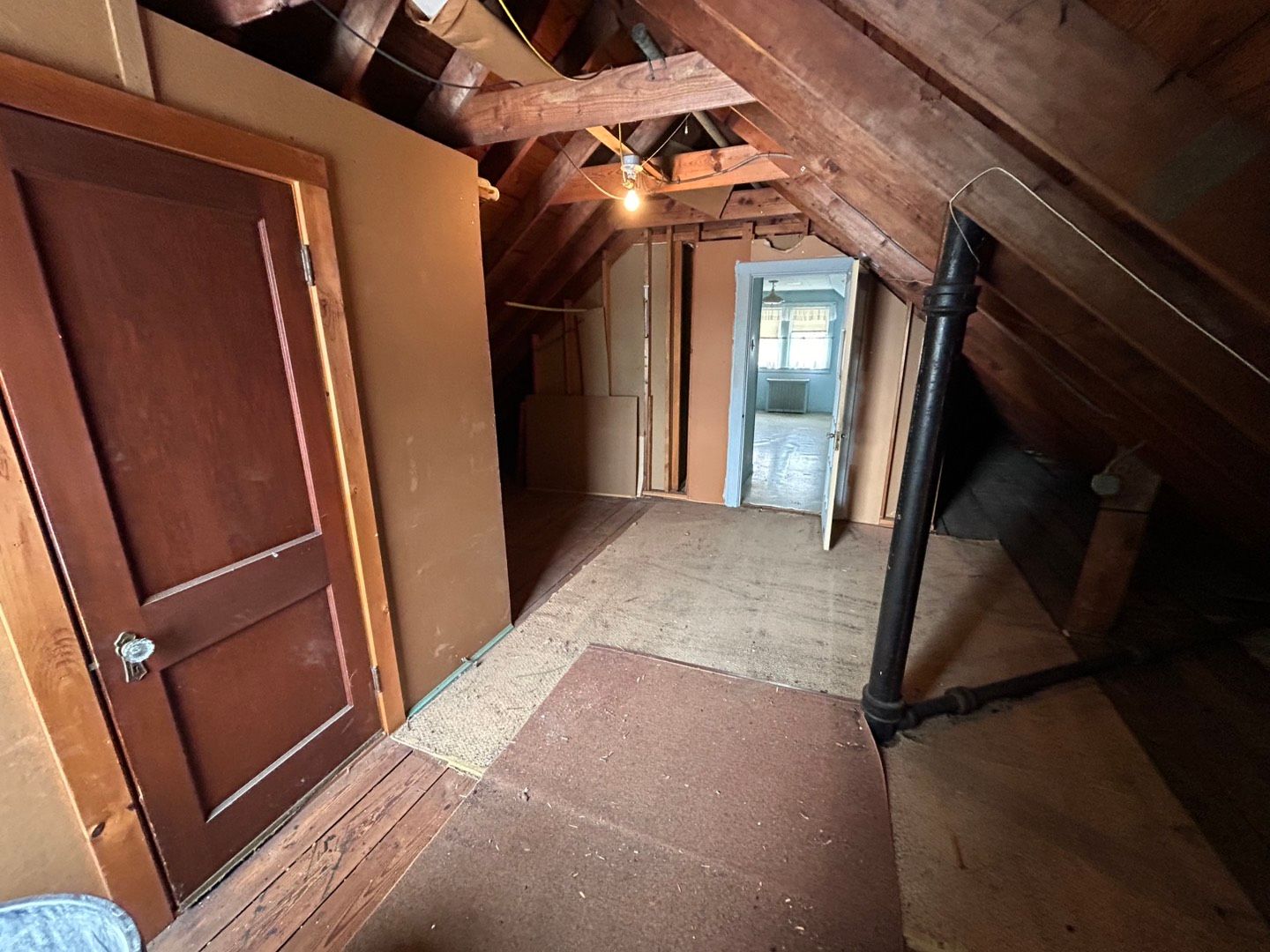 An attic with a door and a mirror in it