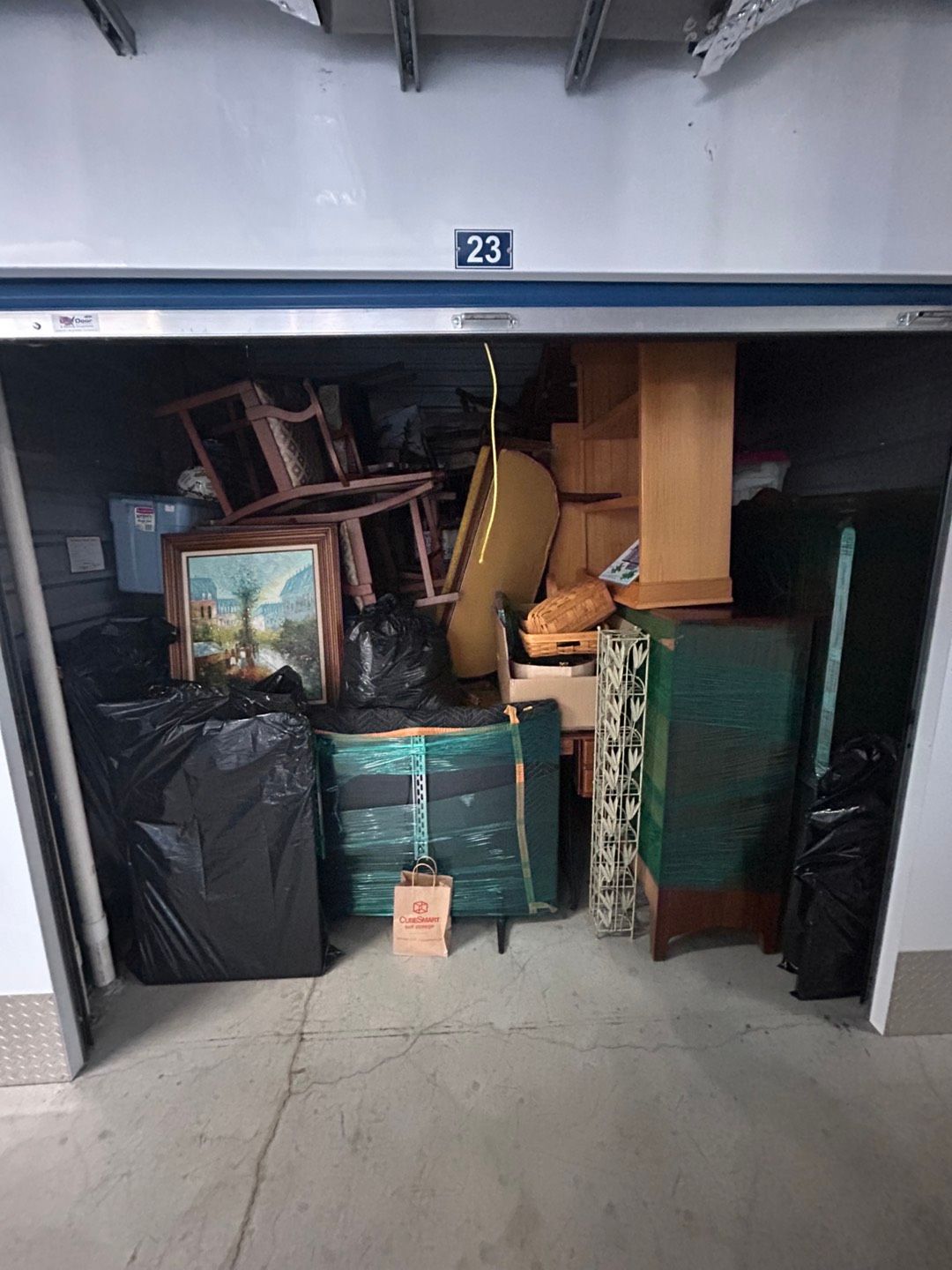 A garage filled with lots of furniture and bags.