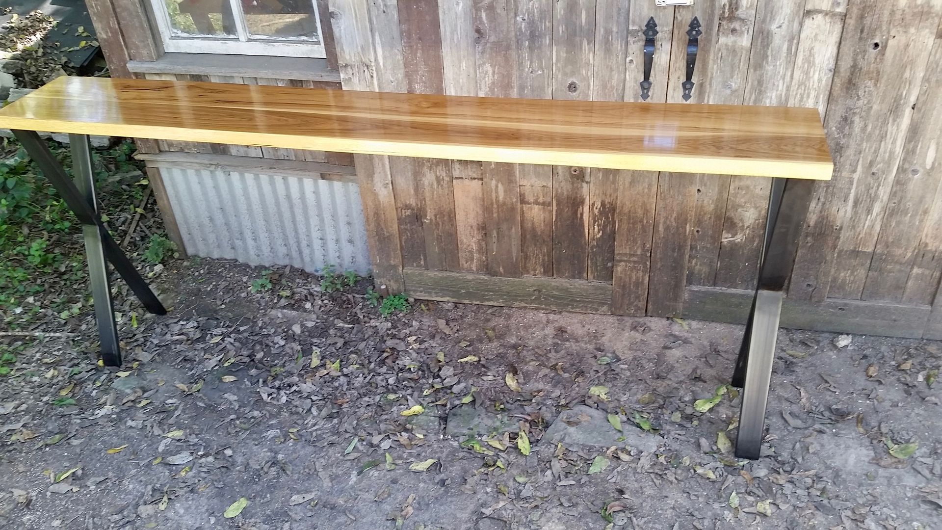 A wooden bench is sitting on the ground in front of a wooden building.