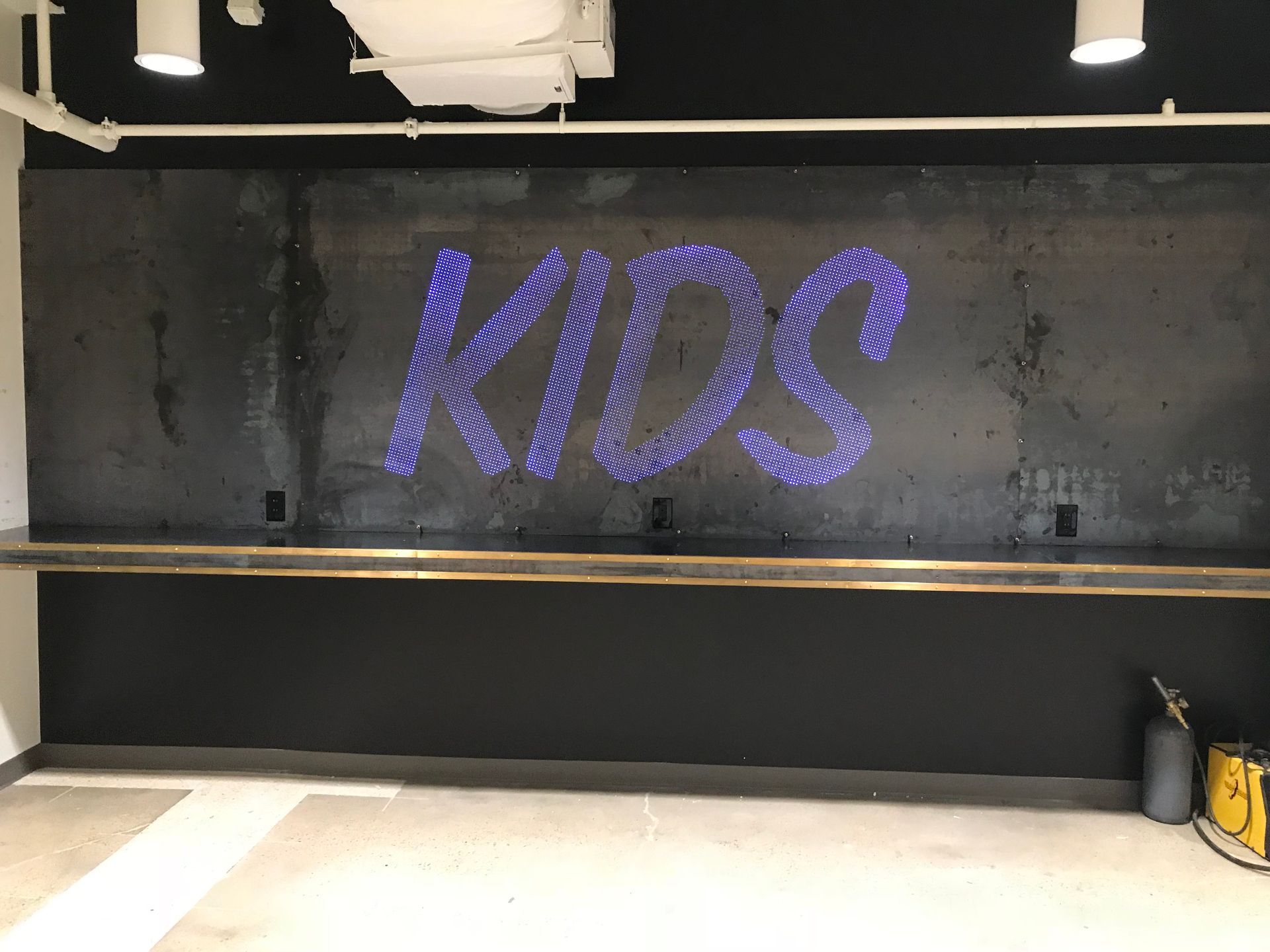 A black wall with the word kids written on it