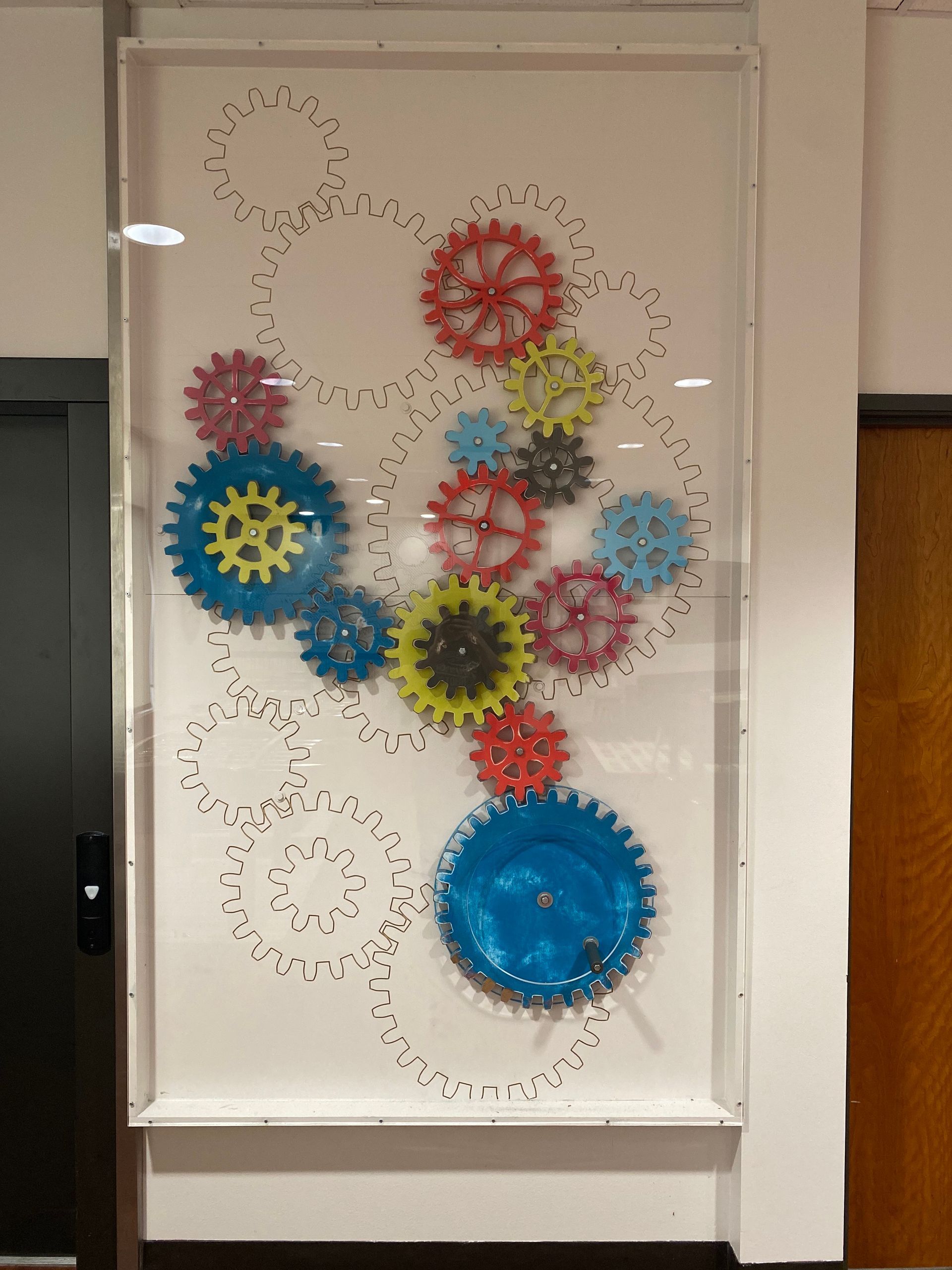 A display of colorful gears on a white wall