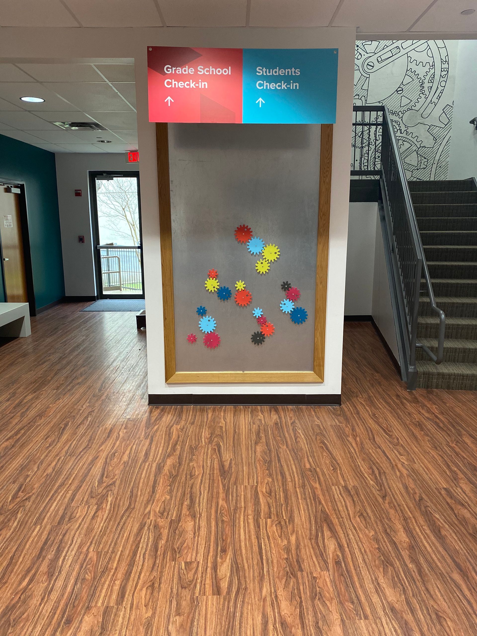 A hallway with wooden floors and a sign on the wall.