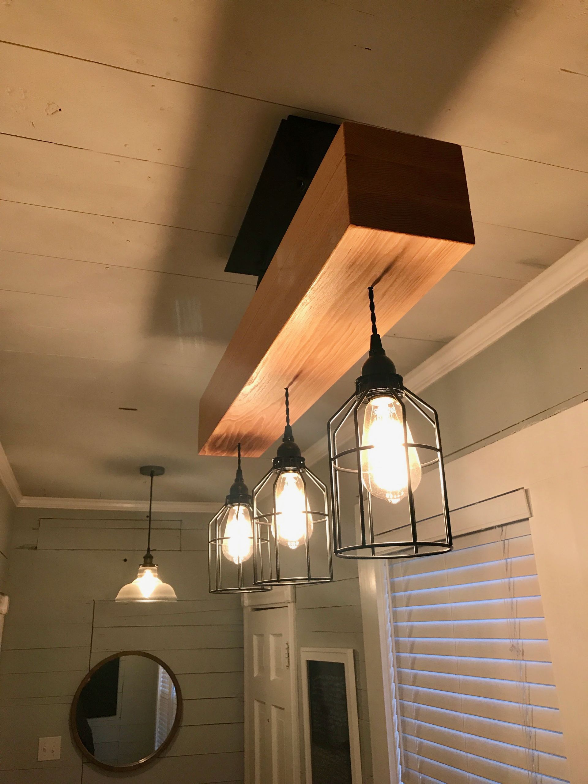 A dining room with a wooden beam hanging from the ceiling.