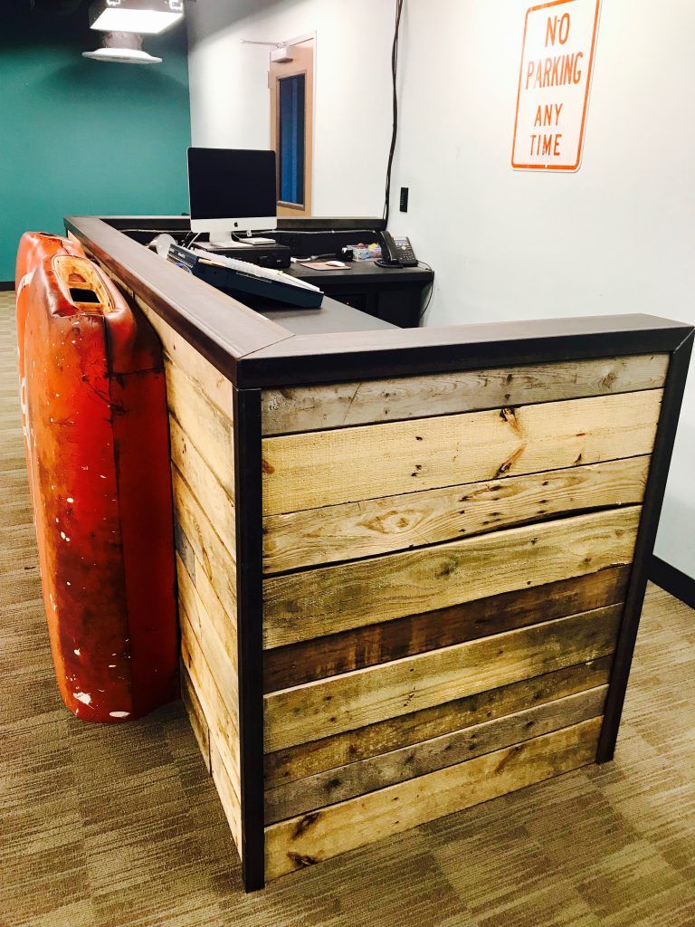 A wooden reception desk with a no parking sign on the wall
