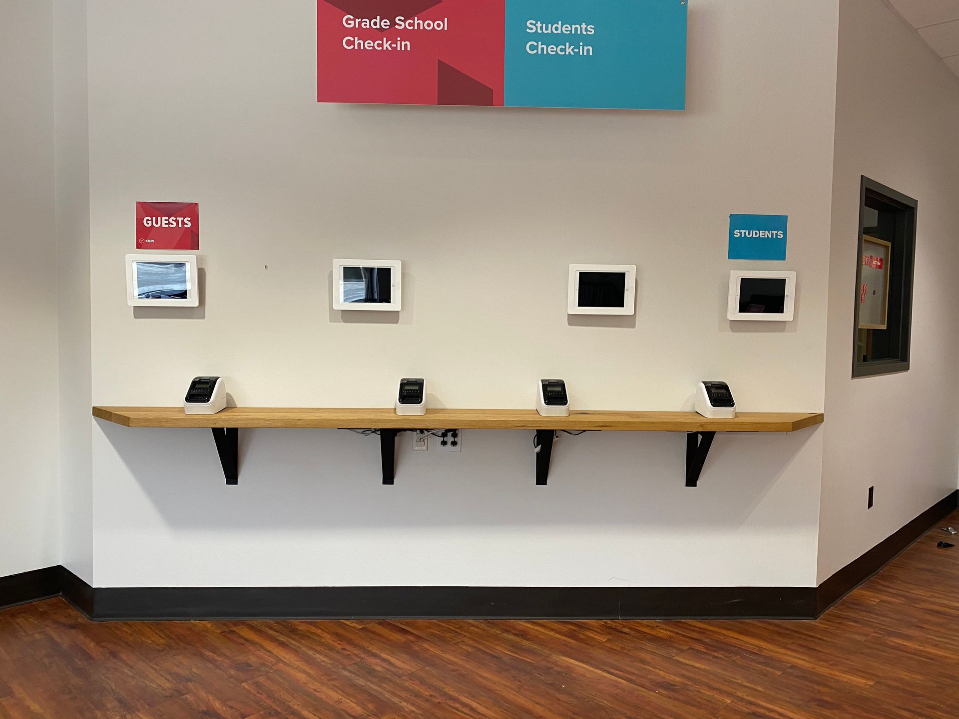 A wall with a wooden shelf and a sign above it