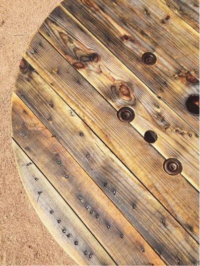 A close up of a wooden spool with holes in it