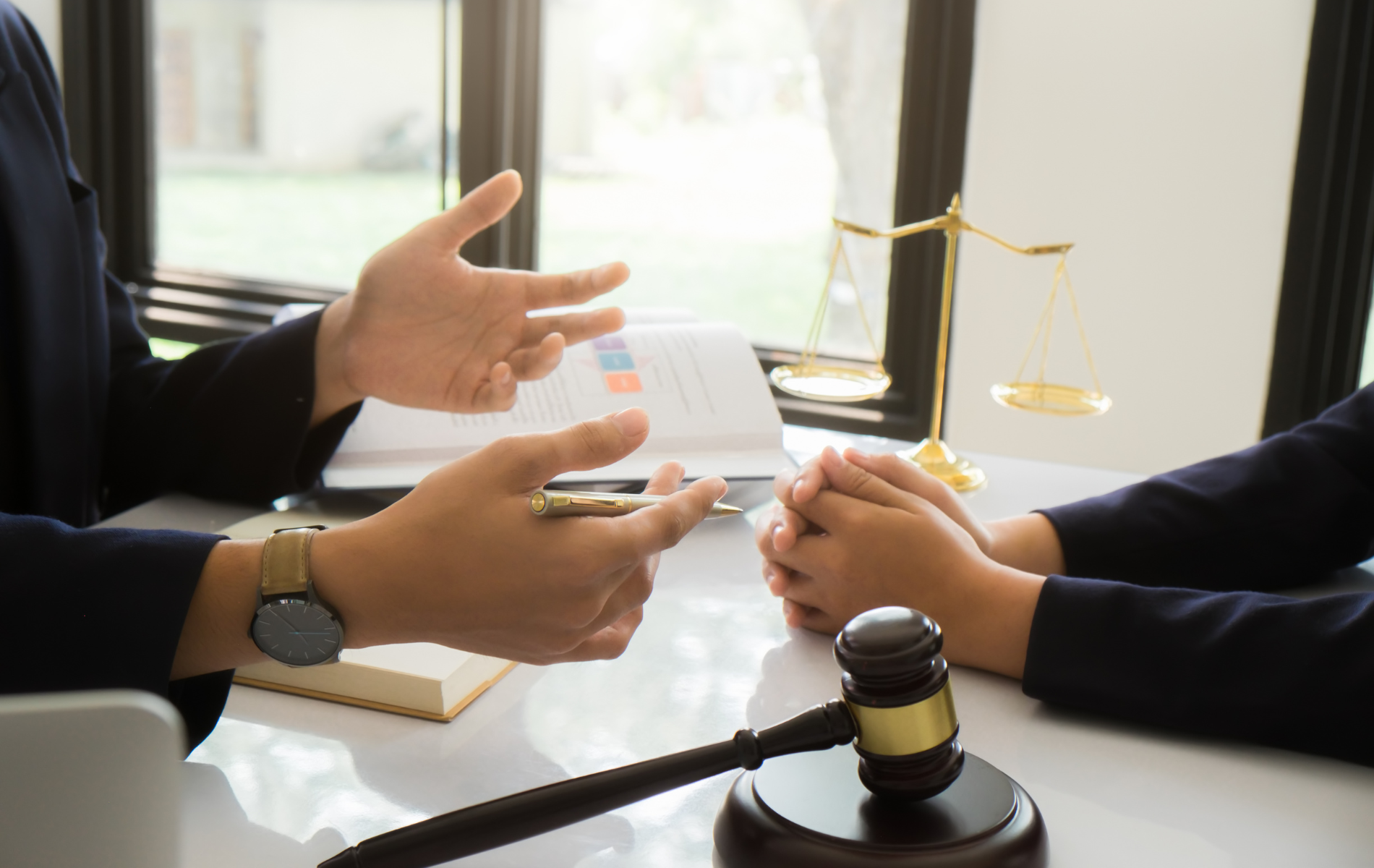 A man and a woman are sitting at a table with a gavel in front of them.