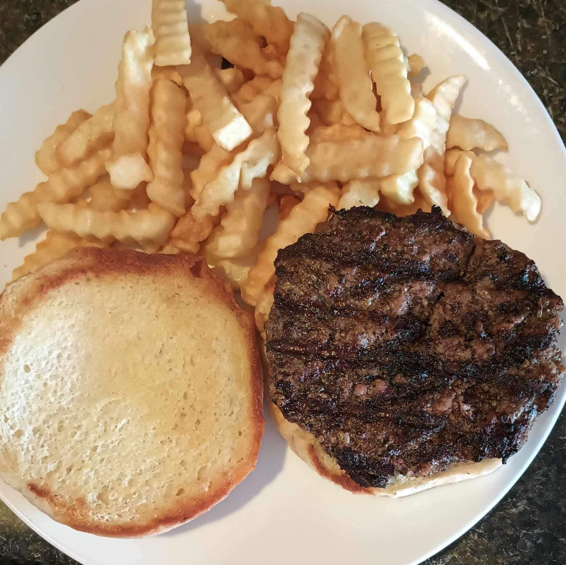 A white plate topped with a hamburger and french fries