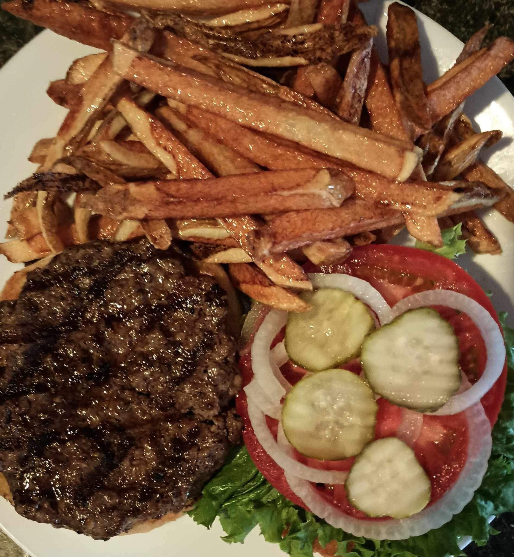 A white plate topped with a hamburger and french fries