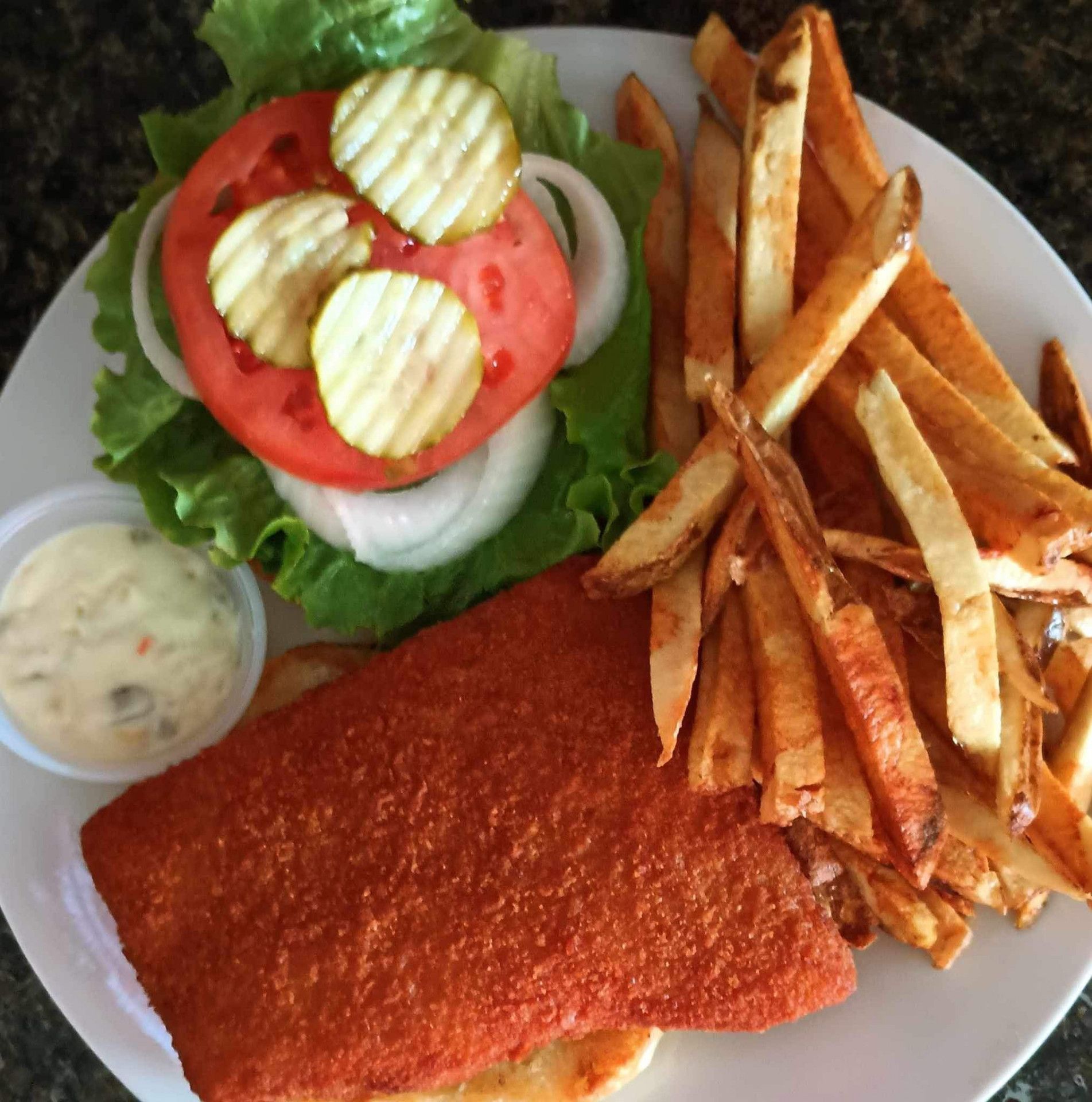 A white plate topped with french fries and a sandwich