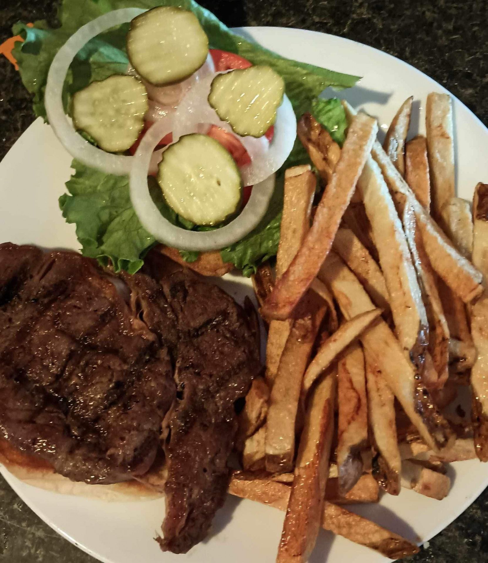 A white plate topped with a steak and french fries