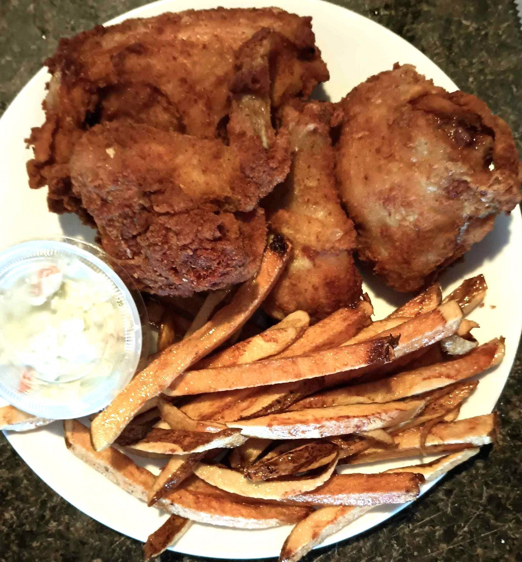 A white plate topped with fried chicken and french fries