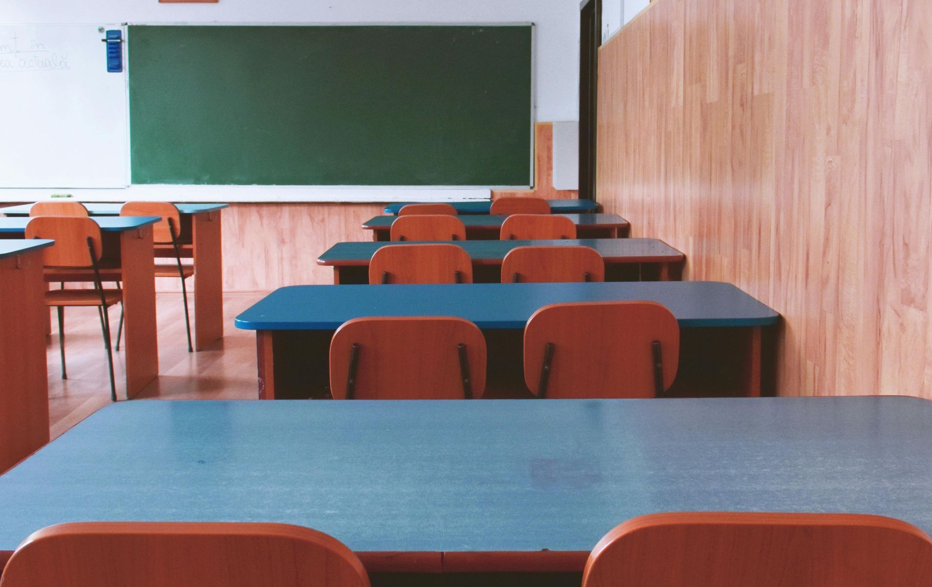 An empty classroom with desks & chairs, symbolising the challenge of school avoidance and absenteeis