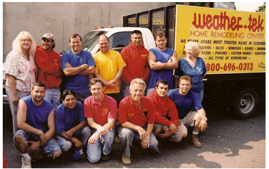 A group of diverse people in front of a yellow truck with 