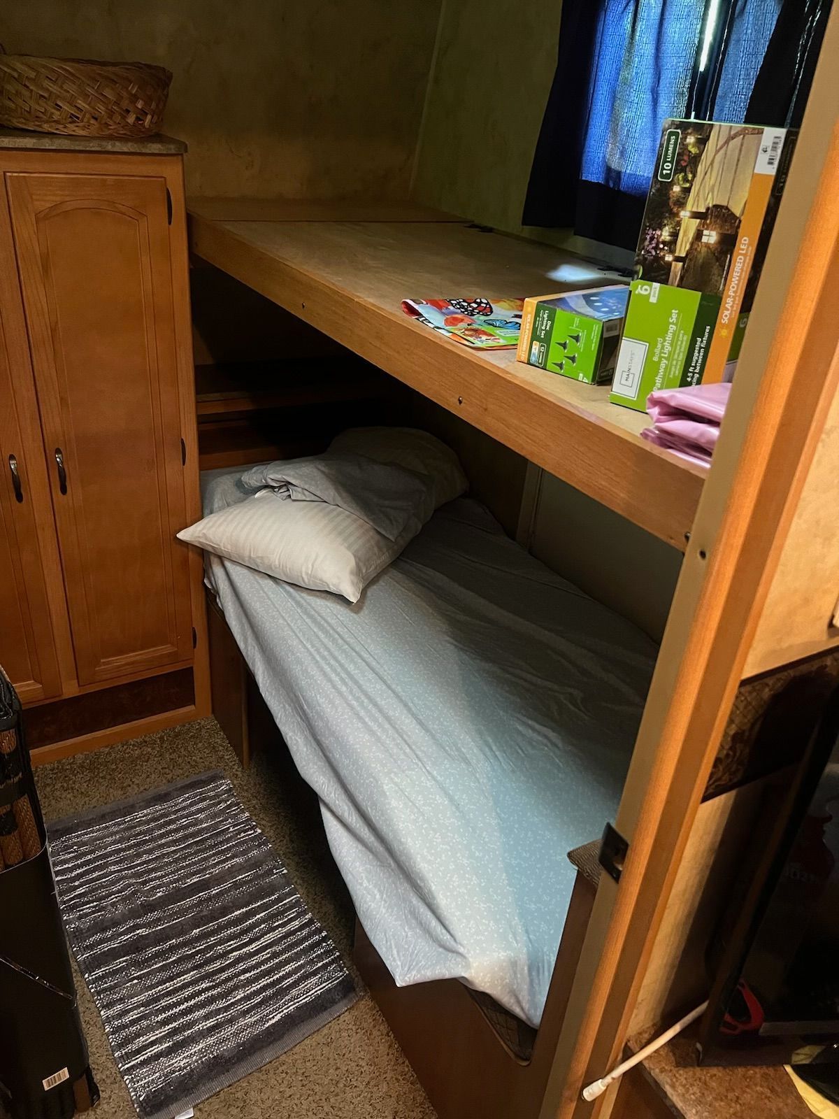 A bunk bed with a pillow on top of it in a room