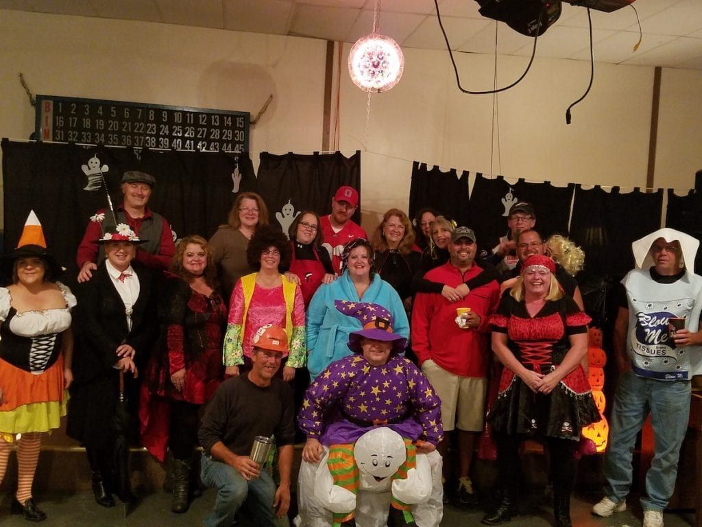 A group of people in halloween costumes pose for a picture