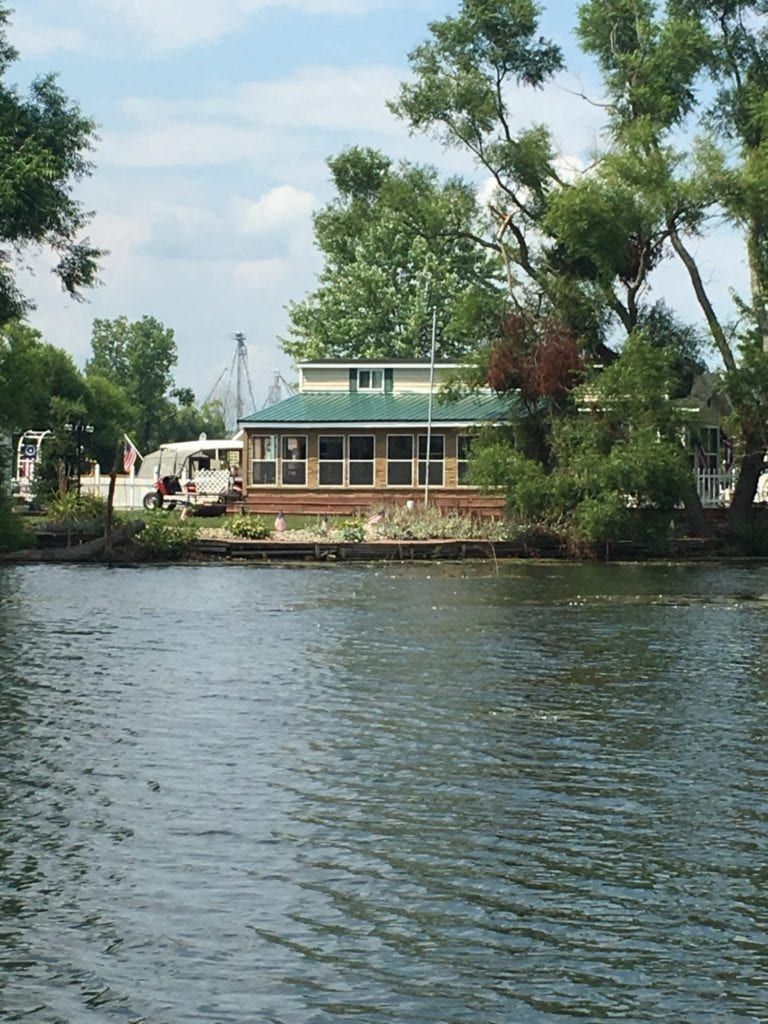 A house sits on a small island in the middle of a lake