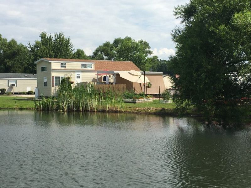 A house sits on a small island in the middle of a lake