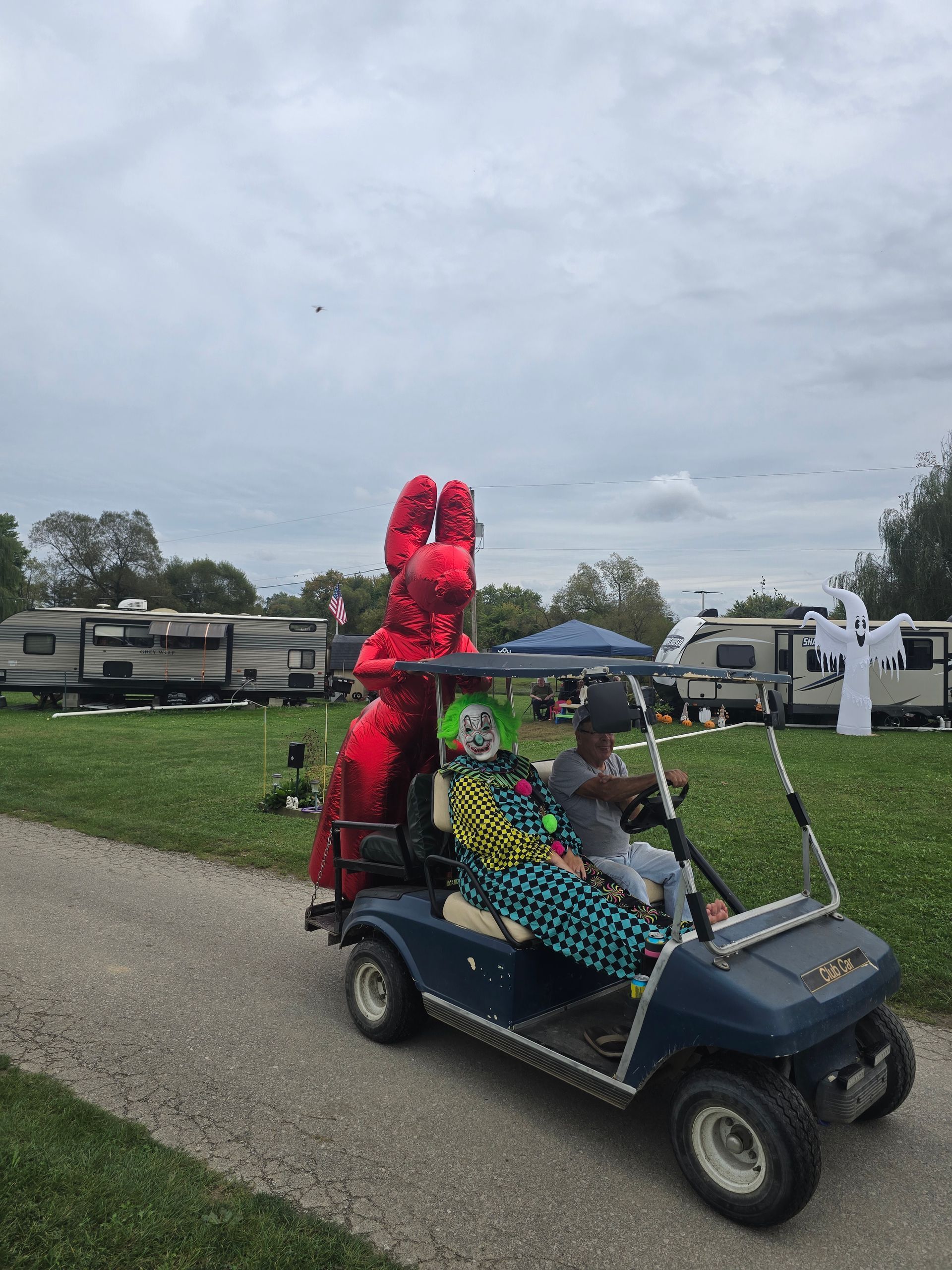 A person is riding a golf cart with balloons on the back