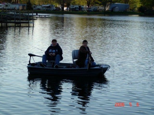 Two men are fishing in a small boat on a lake