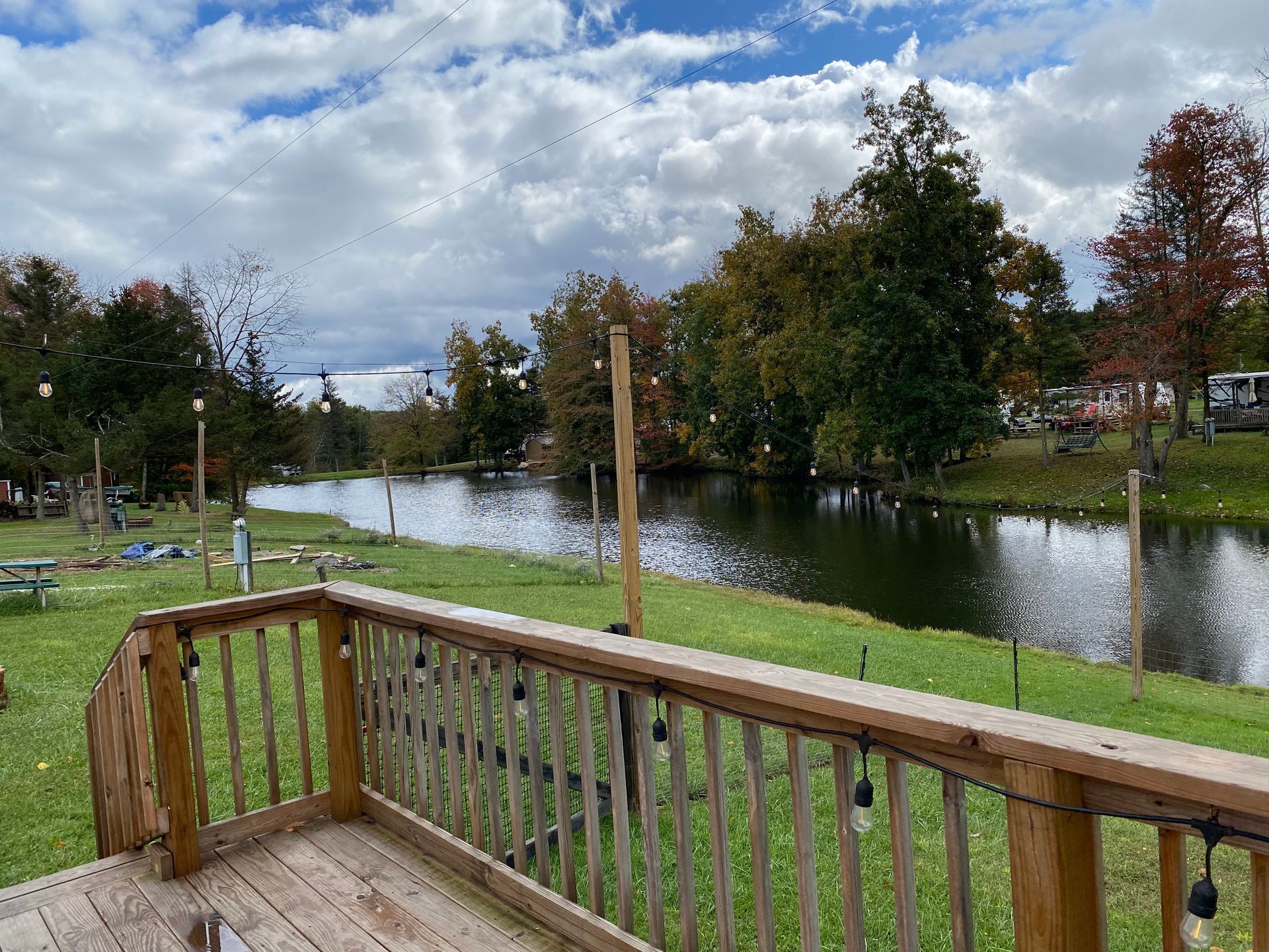 A wooden deck overlooking a lake with trees in the background