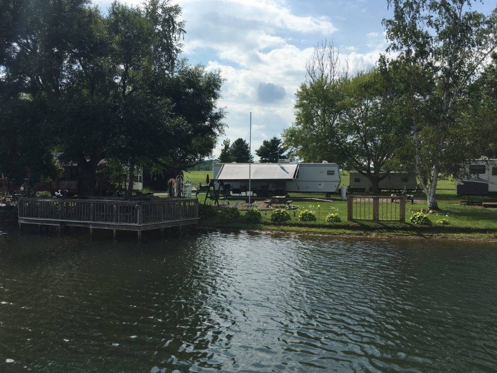 A lake with a dock and a house in the background