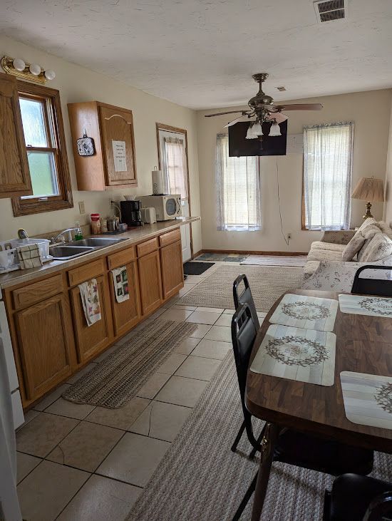 A kitchen with a table and chairs and a ceiling fan