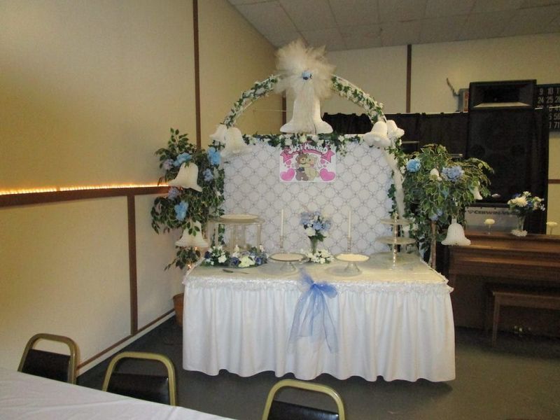 A room with a table and chairs decorated for a baby shower