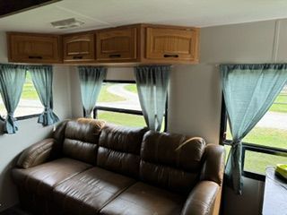 A living room in a trailer with a couch and curtains