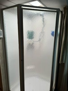 A shower stall with a glass door in a bathroom