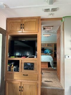 A rv with a tv on top of a wooden cabinet