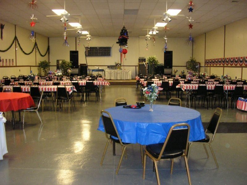 A large room with tables and chairs and a blue table cloth