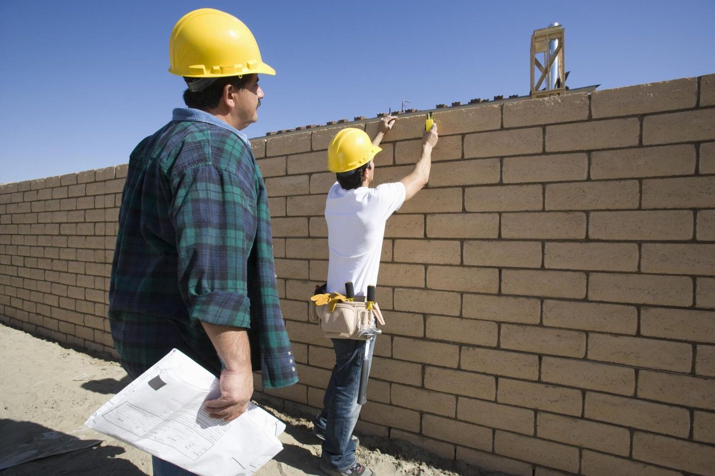 two workers checking the walls