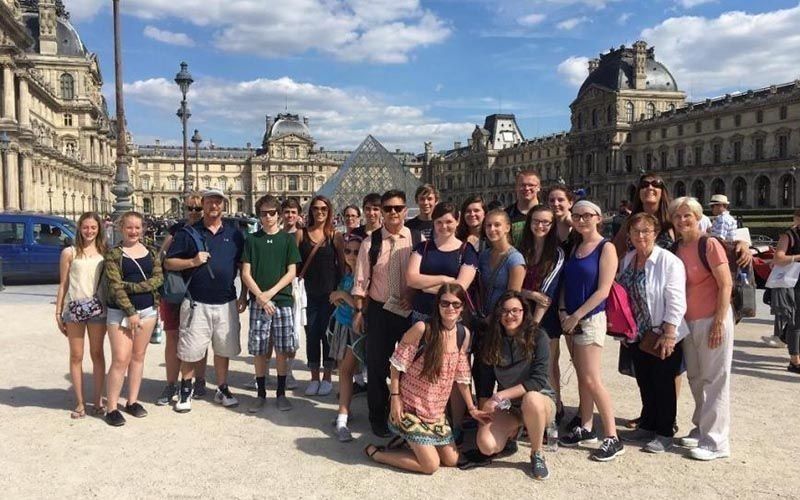A group of people are posing for a picture in front of a building.