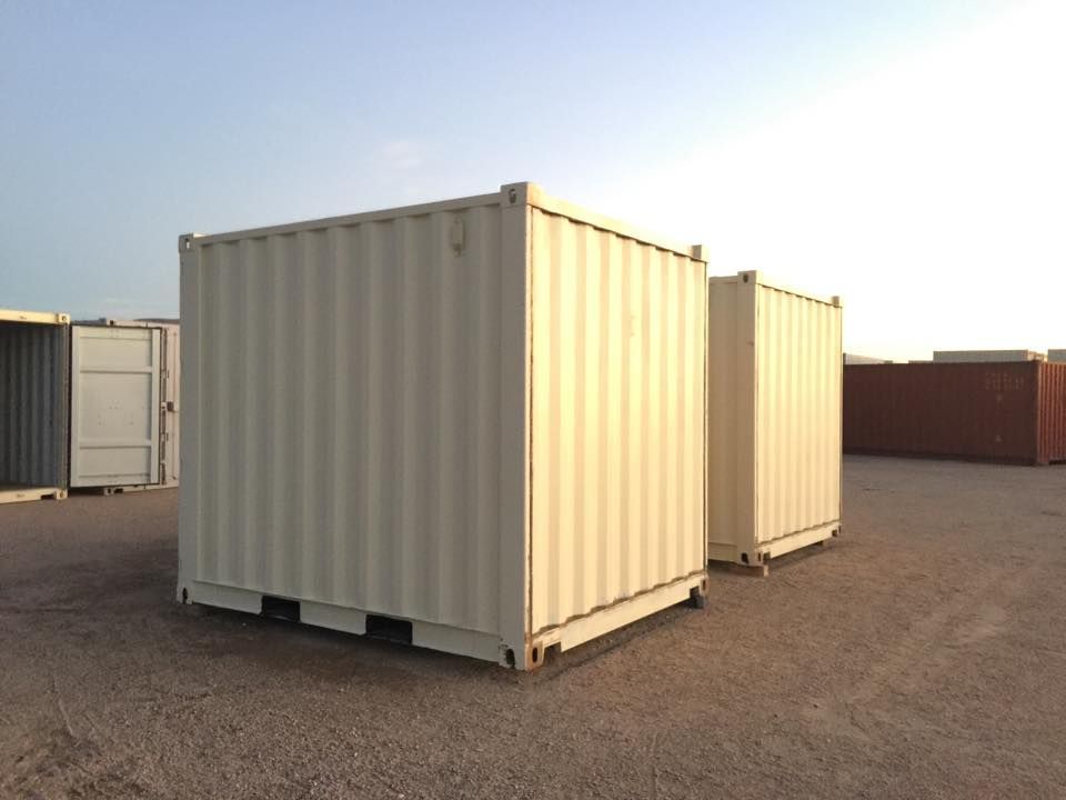 Two shipping containers are sitting next to each other in a parking lot.
