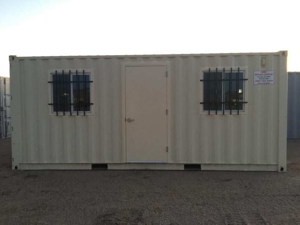 A white shipping container with two windows and a door.