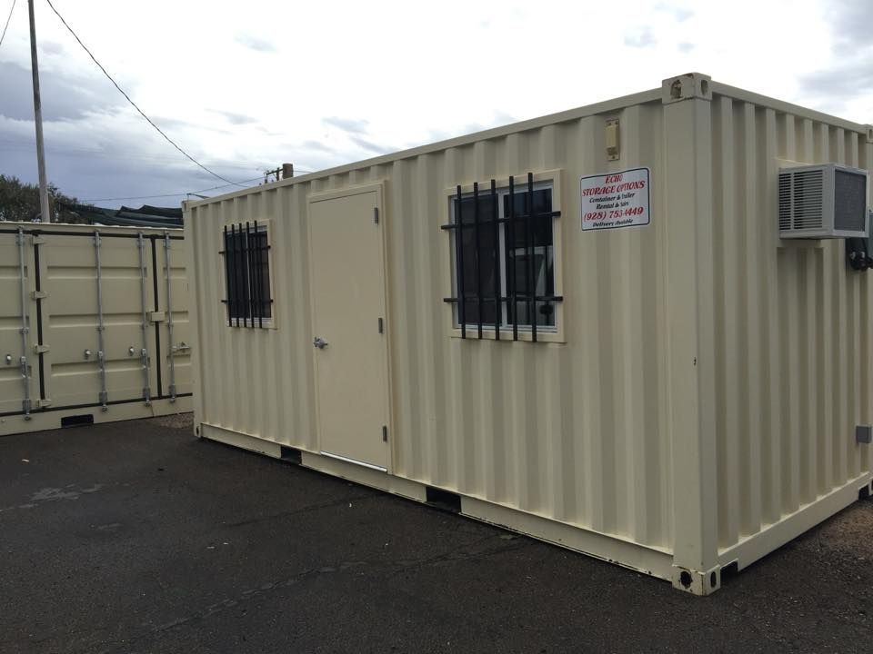 A white shipping container with a window and air conditioner.